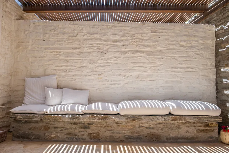 Relaxed lounge corner with soft furnishings and arched stone ceiling