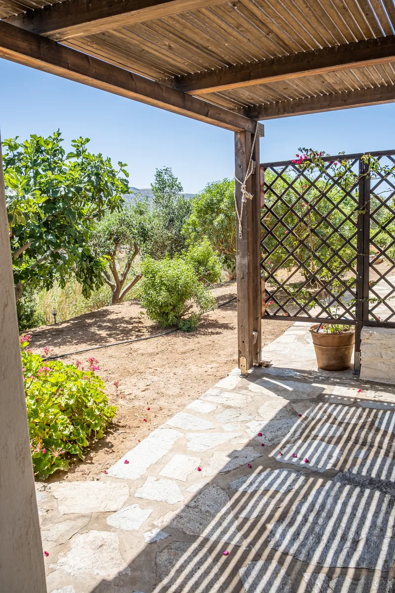 Master suite private garden terrace with sea glimpse through olive trees