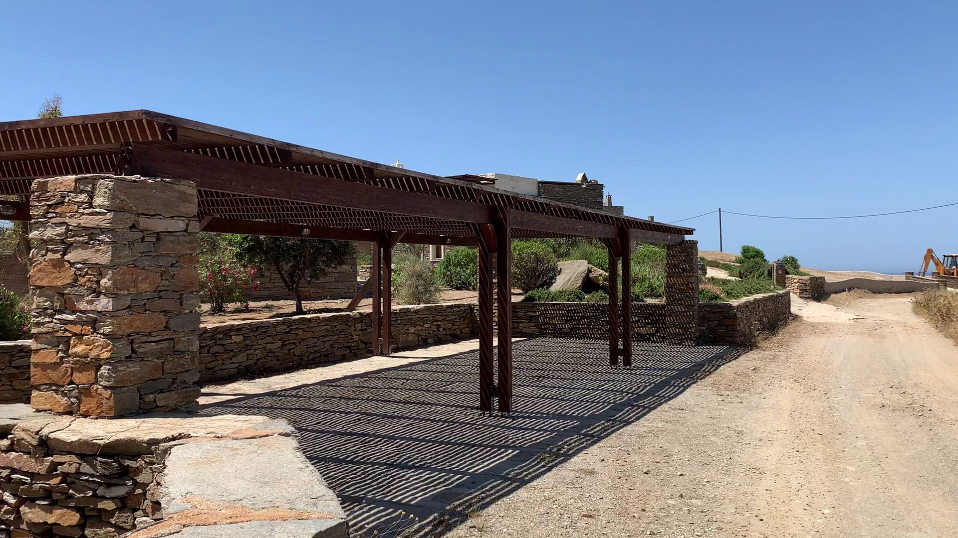 Covered parking pergola at the entrance to the complex with a car parked beneath