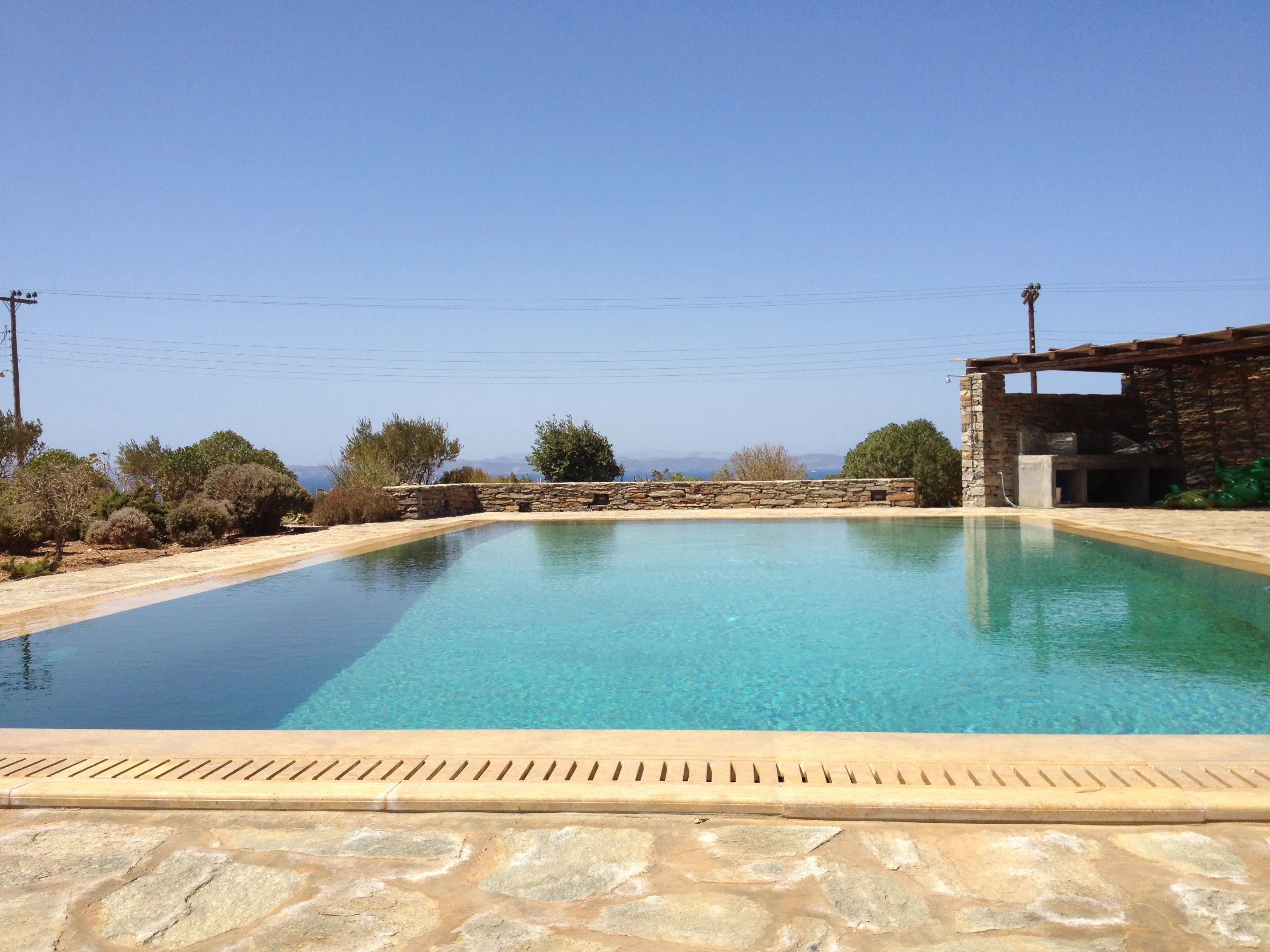 The large shared swimming pool set among stone terracing, with views across the Koundouros hillside