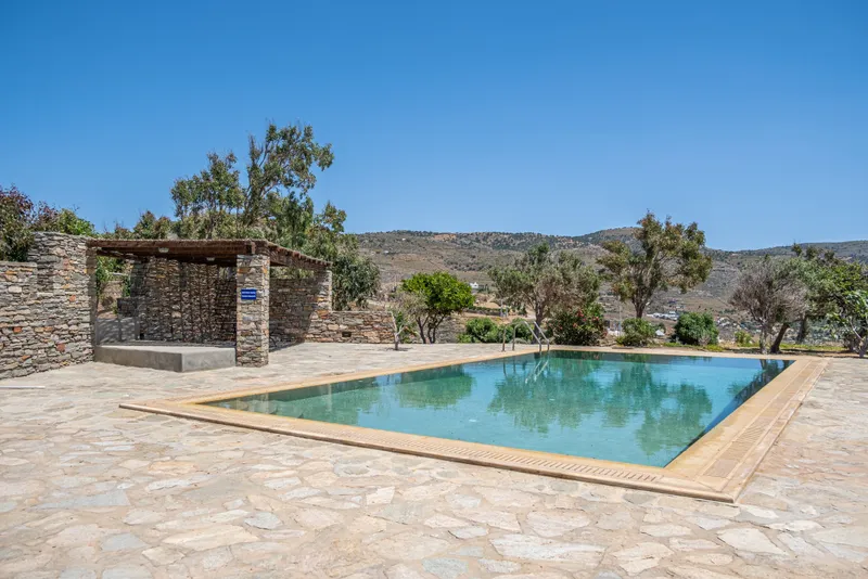Sun loungers arranged on the pool deck beneath a clear sky