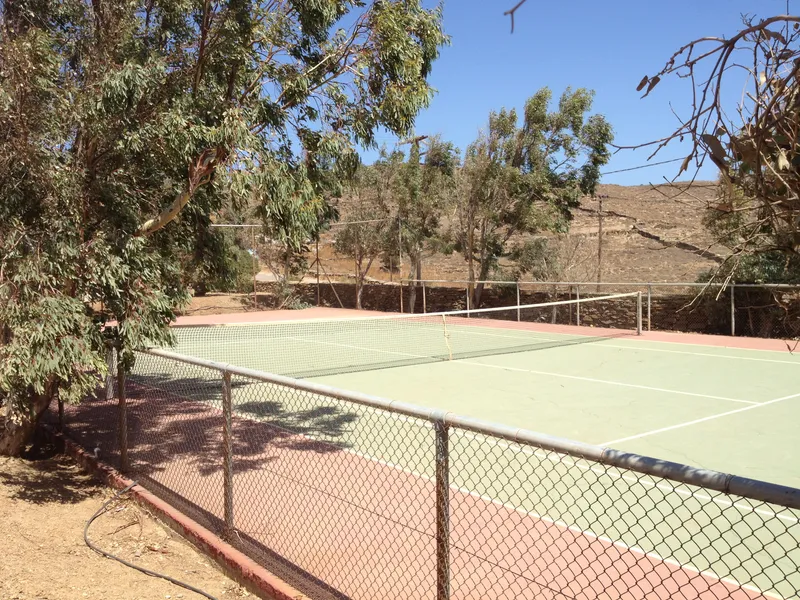 Full-size hard tennis court on the villa grounds